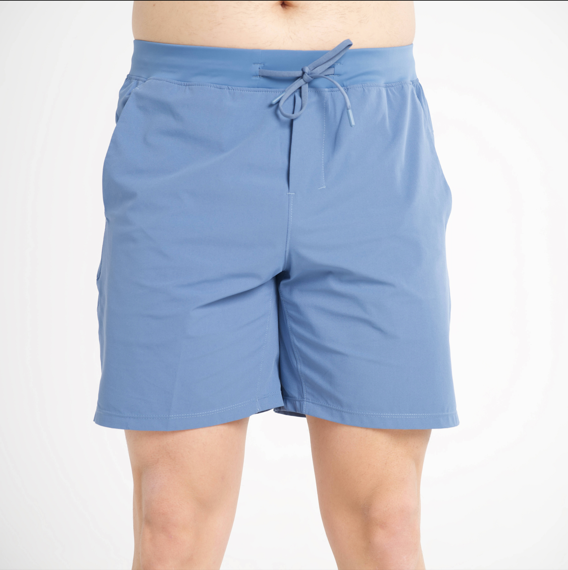 Blue shorts worn by a person on a white background