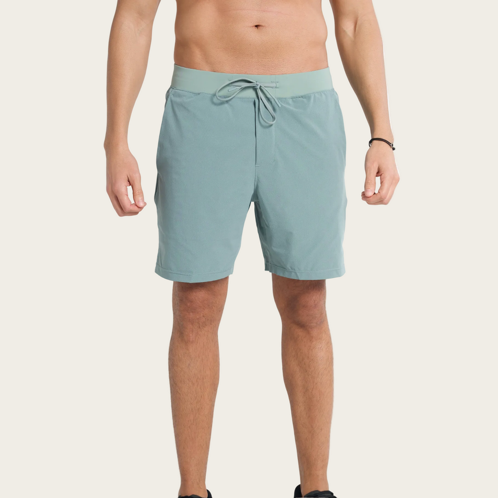 Person wearing light blue shorts on a plain background