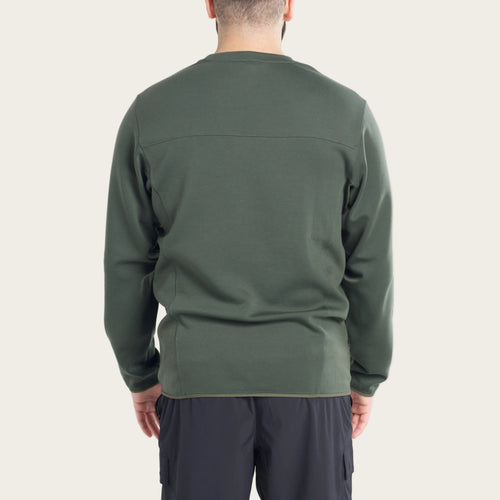 Person wearing a green long-sleeve shirt on a white background