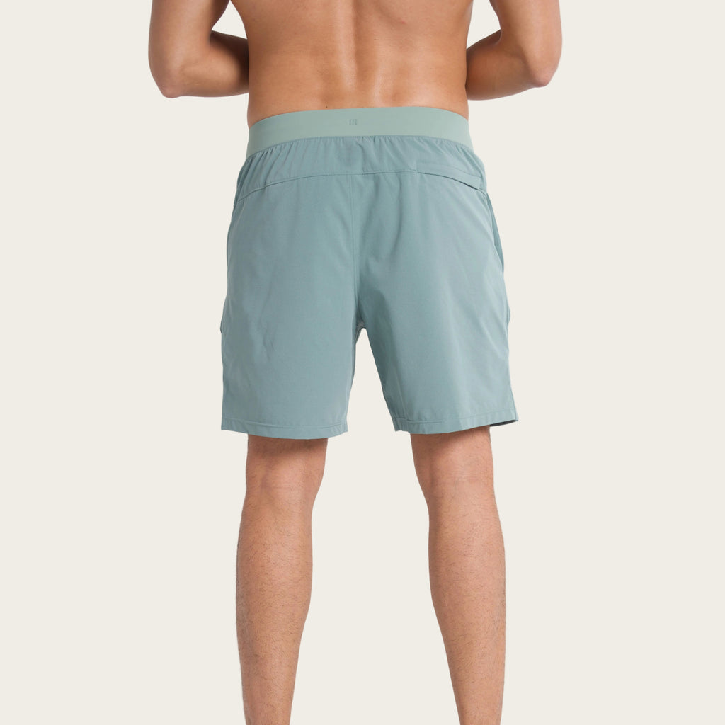 Person wearing light green shorts on a white background
