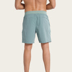 Person wearing light green shorts on a white background