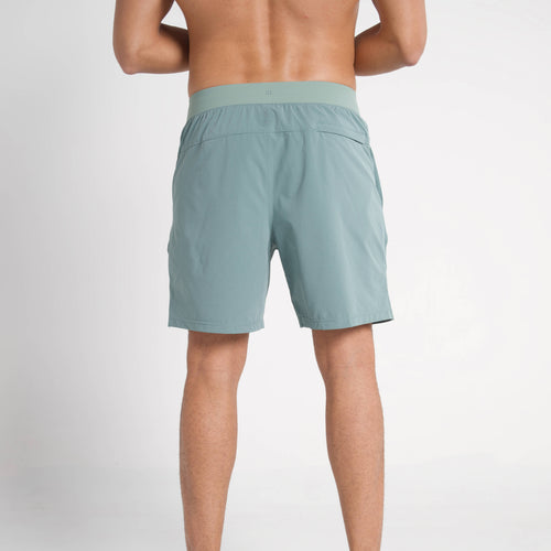 Person wearing light green shorts on a white background