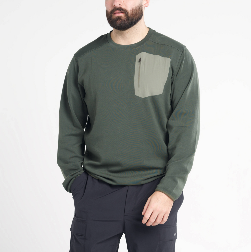 Man wearing a green long-sleeve shirt with a pocket on a white background