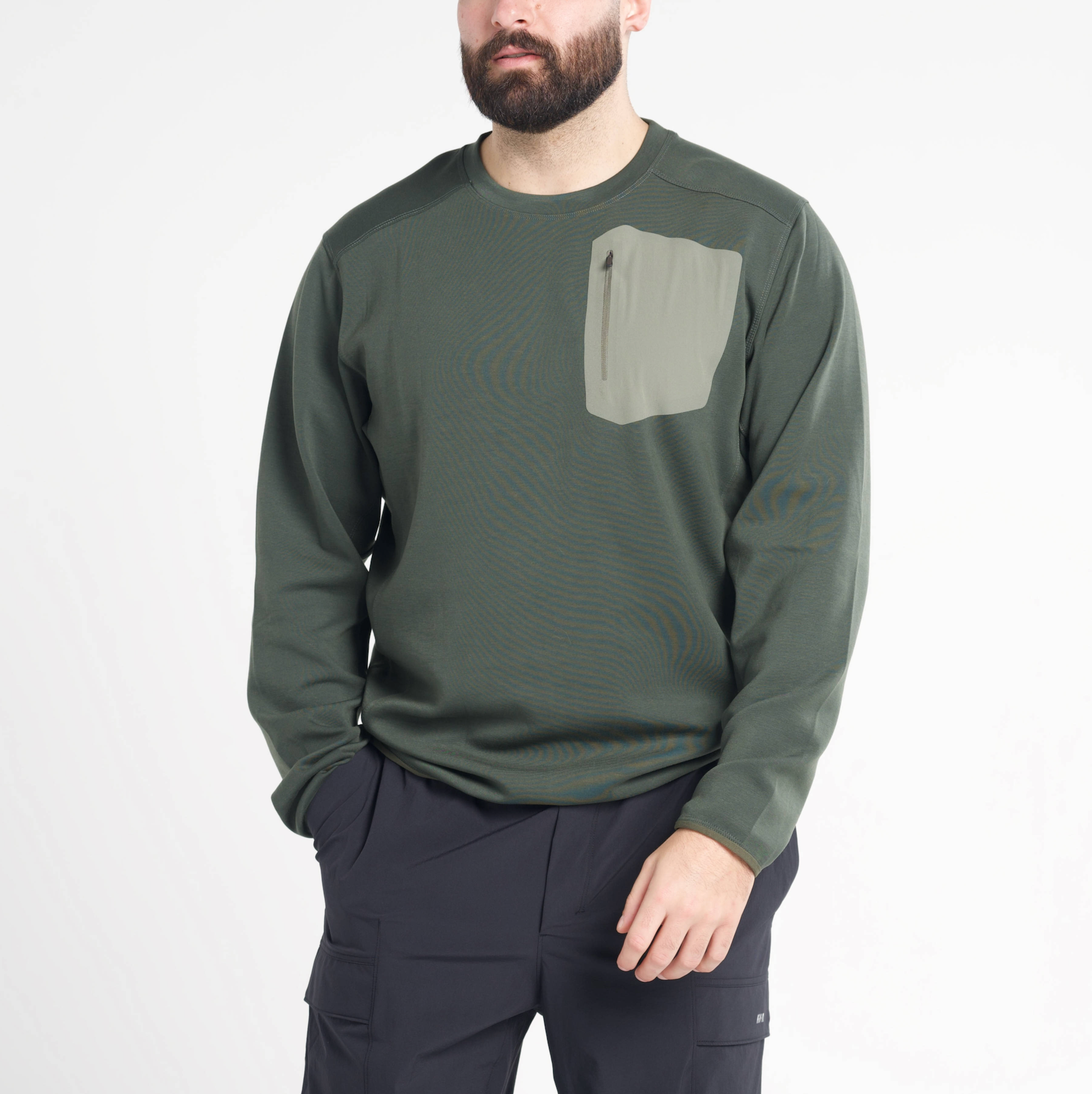 Man wearing a green long-sleeve shirt with a pocket on a white background